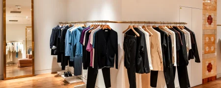 Intérieur de la boutique Sandro à La Défense avec rayons prêt-à-porter, mobilier retail et éclairage intégré