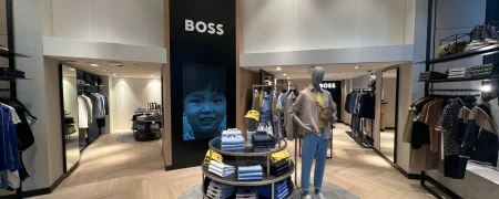 Intérieur d’une boutique BOSS avec mobilier retail, collections prêt-à-porter et ambiance premium