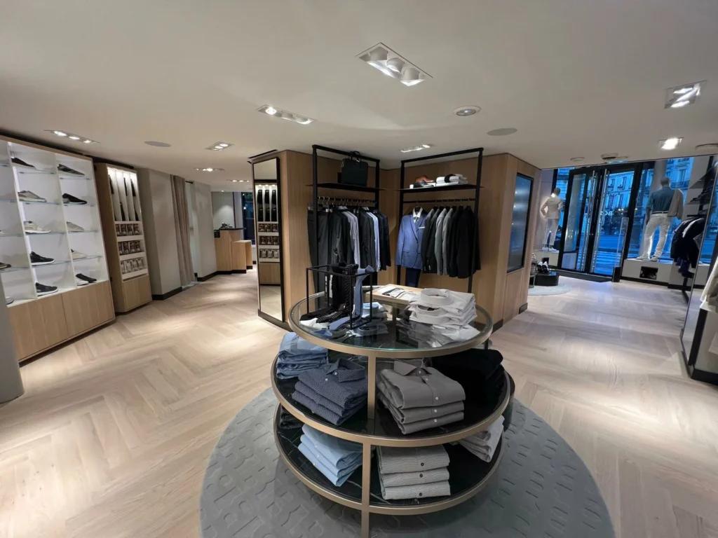 Rayons prêt-à-porter BOSS avec portants, mobilier retail et éclairage de boutique