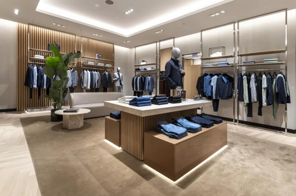 Mobilier bois, portants vêtements et table centrale dans la boutique BOSS Parly 2