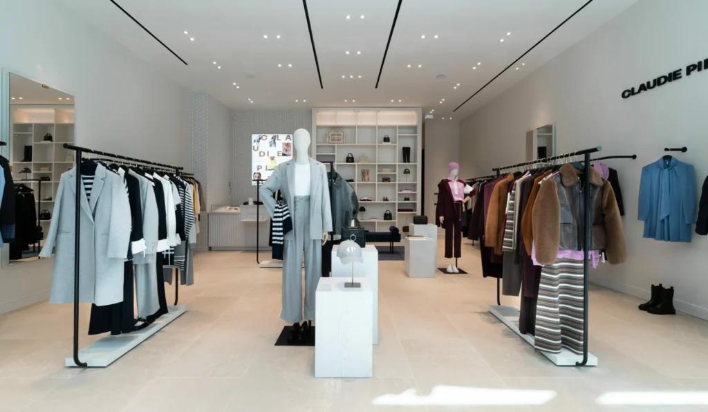 Vue de face de la boutique Claudie Pierlot Grenoble avec mobilier retail, portants et ambiance élégante