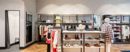 Intérieur d’une boutique GANT à Paris avec mobilier retail, vêtements, chaussures et linéaires muraux