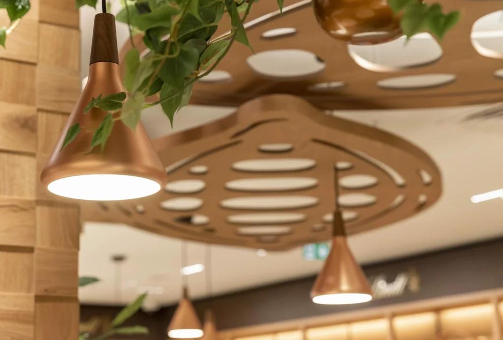 Suspensions cuivrées et plafond décoratif dans le flagship Lindt Paris Opéra
