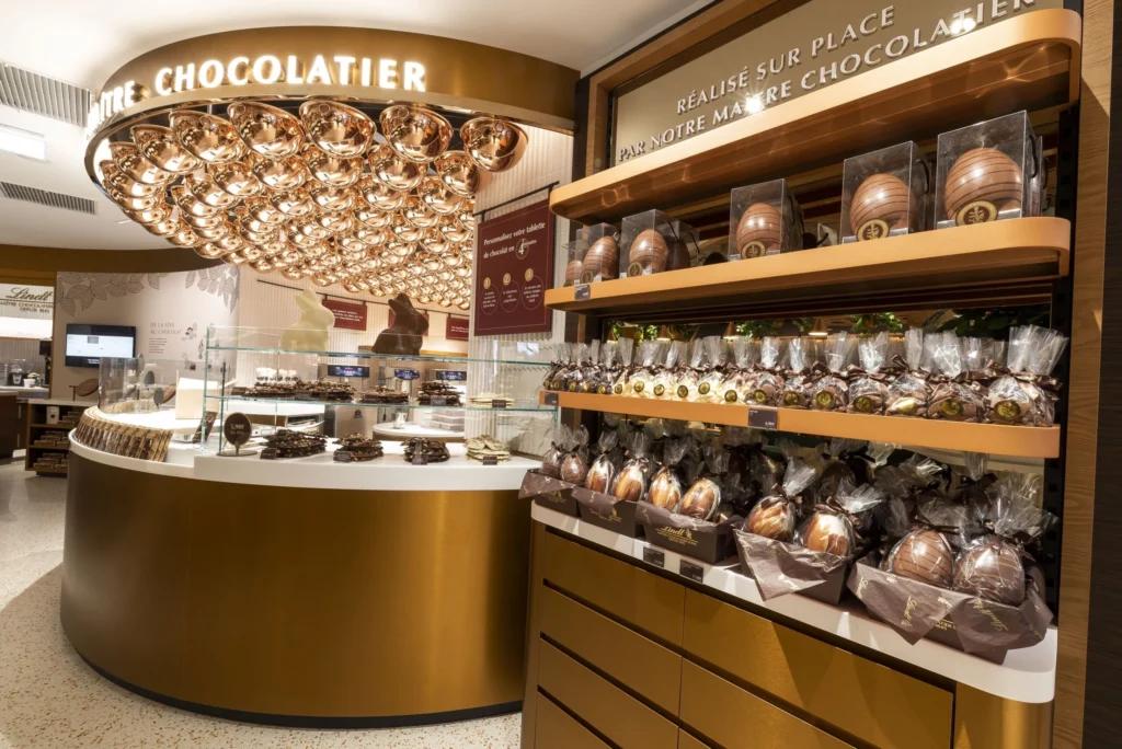 Comptoir chocolatier Lindt Paris Opéra avec chocolats, œufs et mobilier de présentation doré