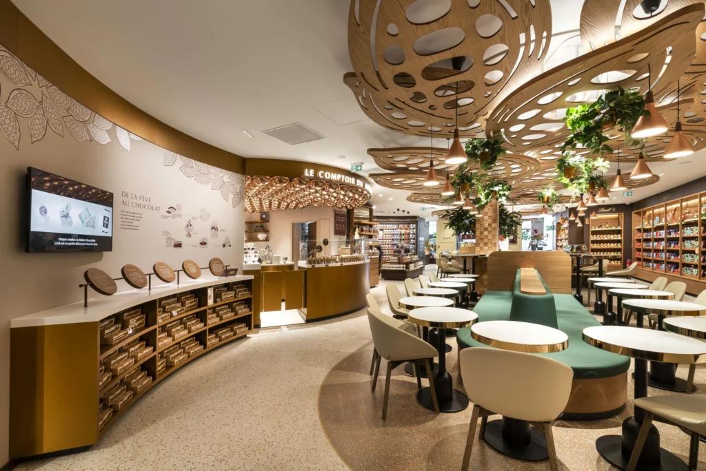 Tables de dégustation et parcours client dans le flagship Lindt Paris Opéra