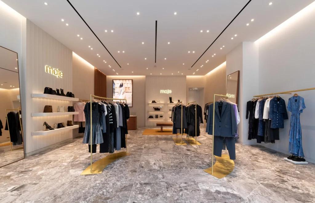 Rayons prêt-à-porter Maje à Grenoble avec étagères rétroéclairées et mobilier retail