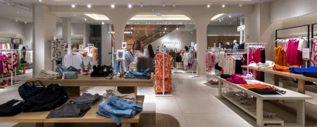 Intérieur de la boutique MANGO Bordeaux avec mobilier bois, arches et collections prêt-à-porter