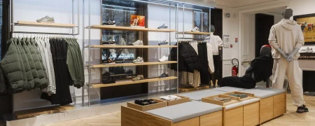 Intérieur de la boutique New Balance Paris Marais avec mobilier retail, sneakers et ambiance premium