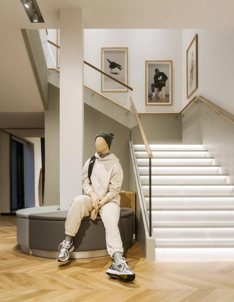 Escalier intérieur de la boutique New Balance Paris Marais avec mobilier retail et parcours client sur deux niveaux