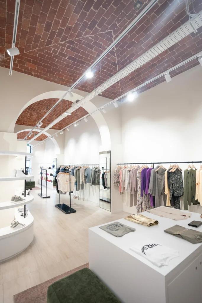 Rayons prêt-à-porter Zadig&Voltaire dans la boutique de Bastia avec mobilier retail et murs en briques
