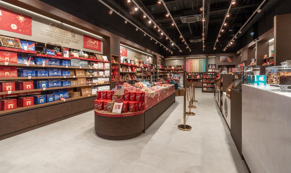Vue en angle de la boutique Lindt Toulon avec espace de vente, mobilier retail et circulation client