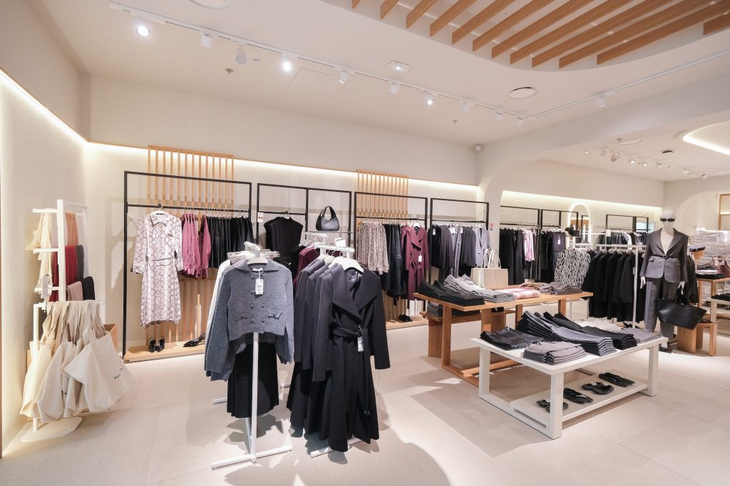 Rayons prêt-à-porter dans la boutique MANGO Rosny avec mobilier mural, éclairage retail et collections mode