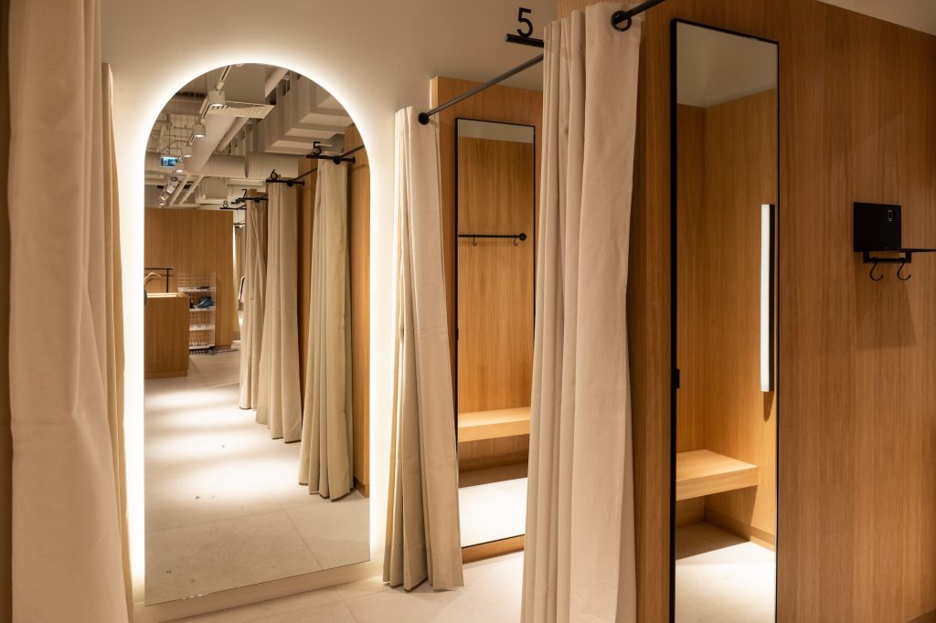 Cabines d’essayage de la boutique MANGO Rosny avec miroirs, rideaux, éclairage et habillage bois