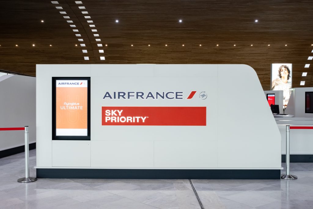 Espace SkyPriority Air France à Roissy avec zones d’accueil, mobilier courbe et circulation passagers
