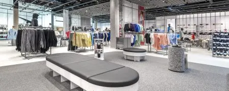 Intérieur du magasin Nike Aéroville avec mobilier retail, collections sport et signalétique de marque