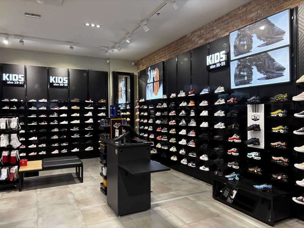 Rayons sneakers et sportwear dans la boutique Foot Locker Rennes avec mobilier retail et éclairage intégré