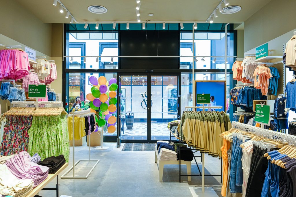 Espace de vente Name It Giverny avec portants, vêtements enfant et mobilier de boutique