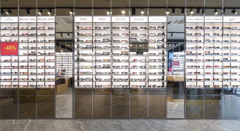 Lunettes exposées dans la boutique SUNGLASS Villefontaine avec mobilier de présentation et éclairage retail