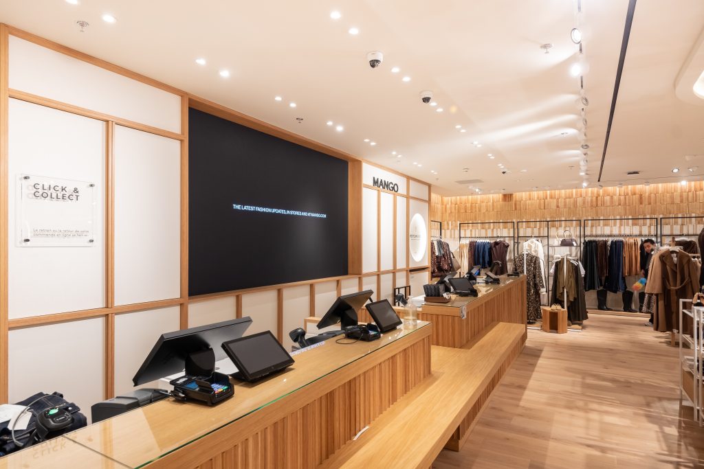 Espace caisses de la boutique MANGO La Défense avec comptoir, mobilier intégré et éclairage