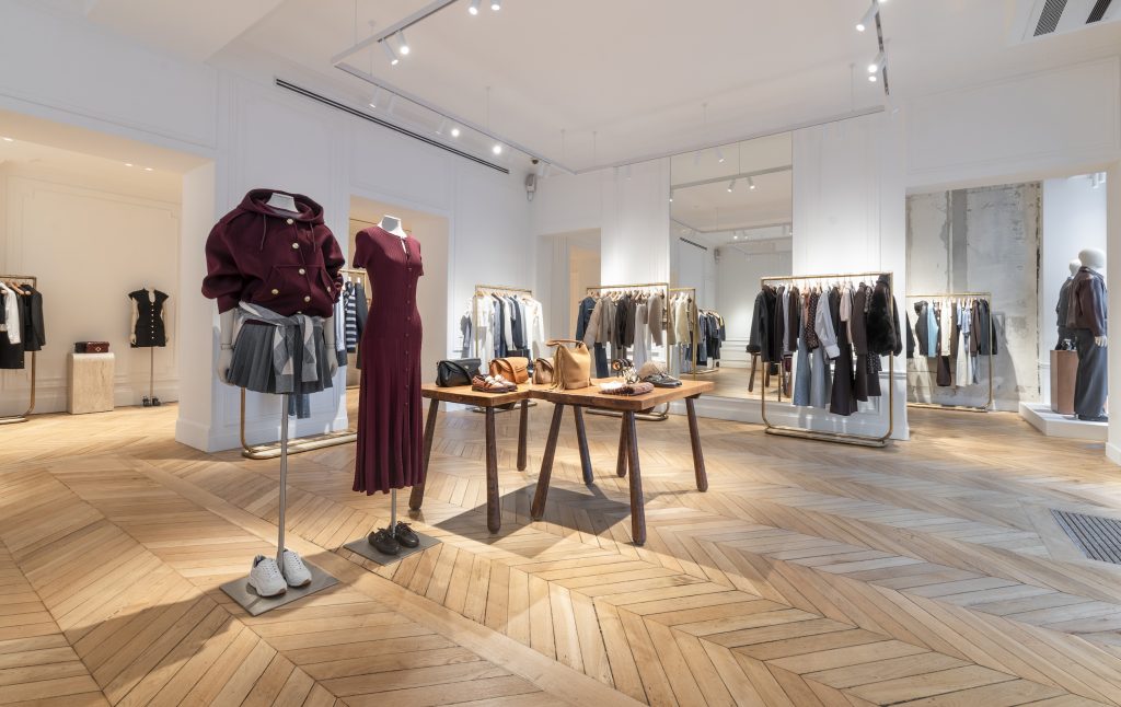 Mannequins et collections prêt-à-porter dans la boutique Sandro Paris Victor Hugo avec parquet en pointe de Hongrie