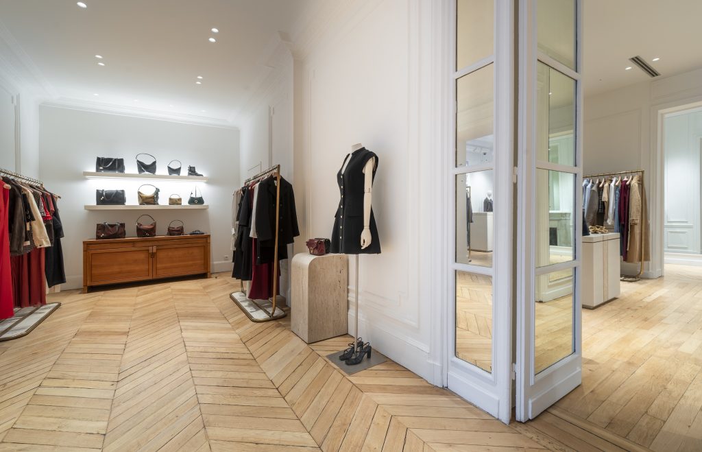 Espace sacs et accessoires dans la boutique Sandro Paris Victor Hugo avec mobilier bois et ambiance élégante
