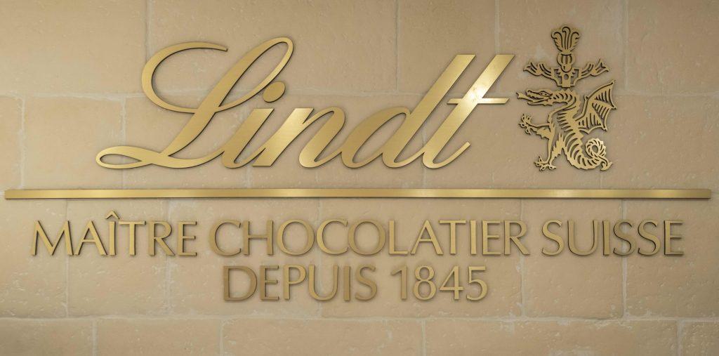 Signalétique murale Lindt maître chocolatier suisse depuis 1845 dans la boutique Cap 3000