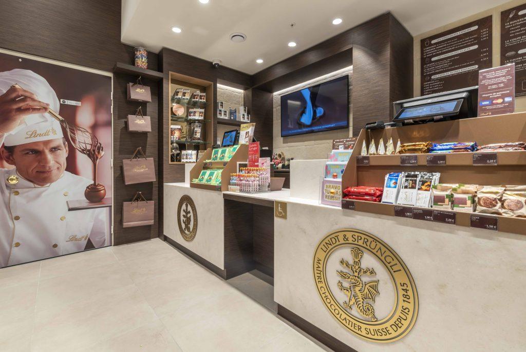 Espace caisse de la boutique Lindt Cap 3000 avec comptoir, mobilier sur mesure et visuel chocolatier