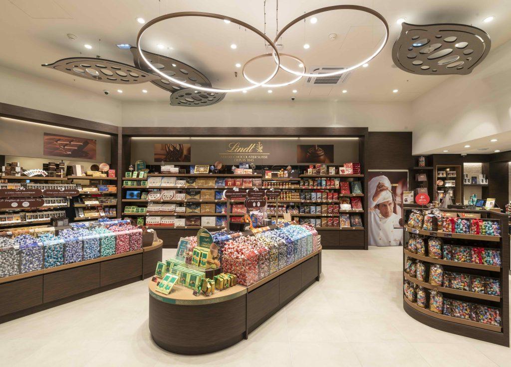 Intérieur de la boutique Lindt Cap 3000 à Nice avec mobilier retail, chocolats et linéaires produits
