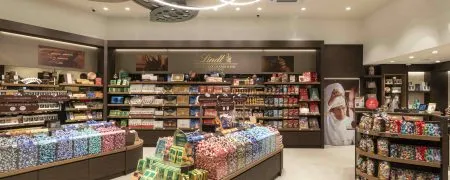 Intérieur de la boutique Lindt Cap 3000 à Nice avec mobilier retail, chocolats et linéaires produits
