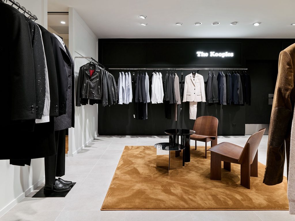 Portants de vêtements homme The Kooples avec signalétique lumineuse, mobilier noir et espace conseil
