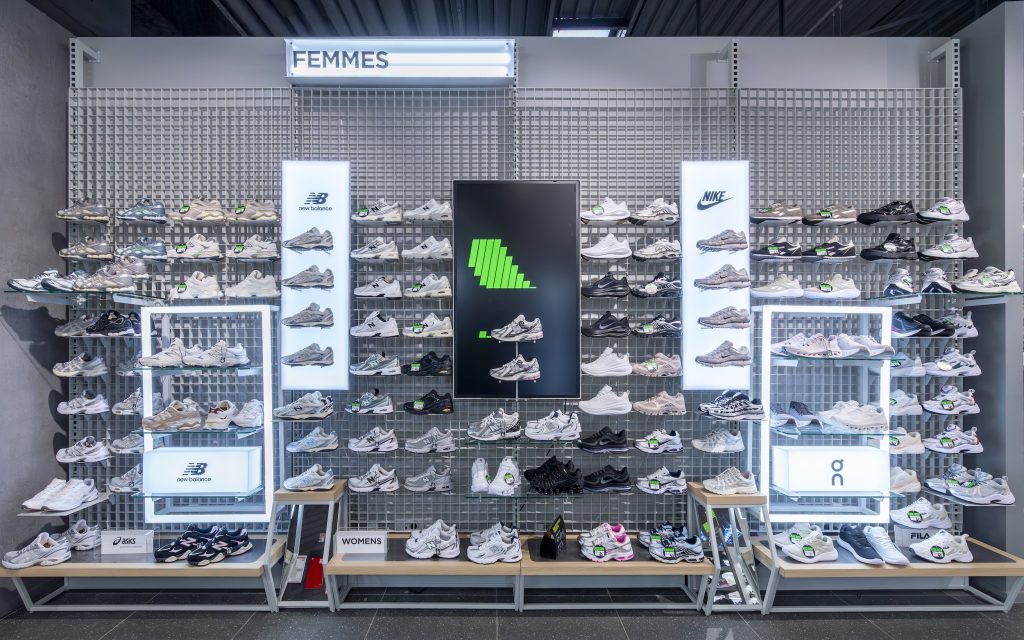 Linéaires de sneakers femmes dans la boutique JD Sports Grenoble avec mobilier mural et éclairage intégré