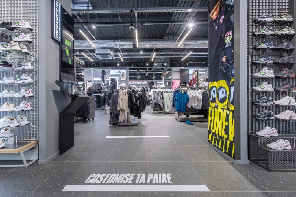 Parcours client dans la boutique JD Sports Grenoble avec rayons sneakers, textile et marquage Customise ta paire