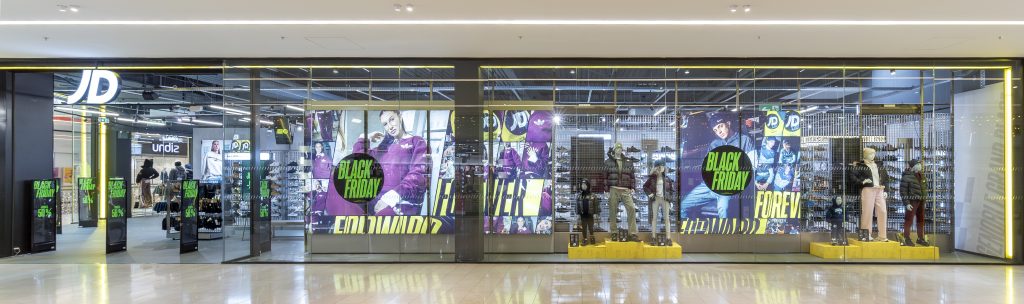 Façade panoramique de la boutique JD Sports Grenoble avec vitrines, enseigne et campagne Black Friday