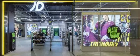 Intérieur de la boutique JD Sports Grenoble avec façade vitrée, mobilier retail, sneakers et campagne Black Friday