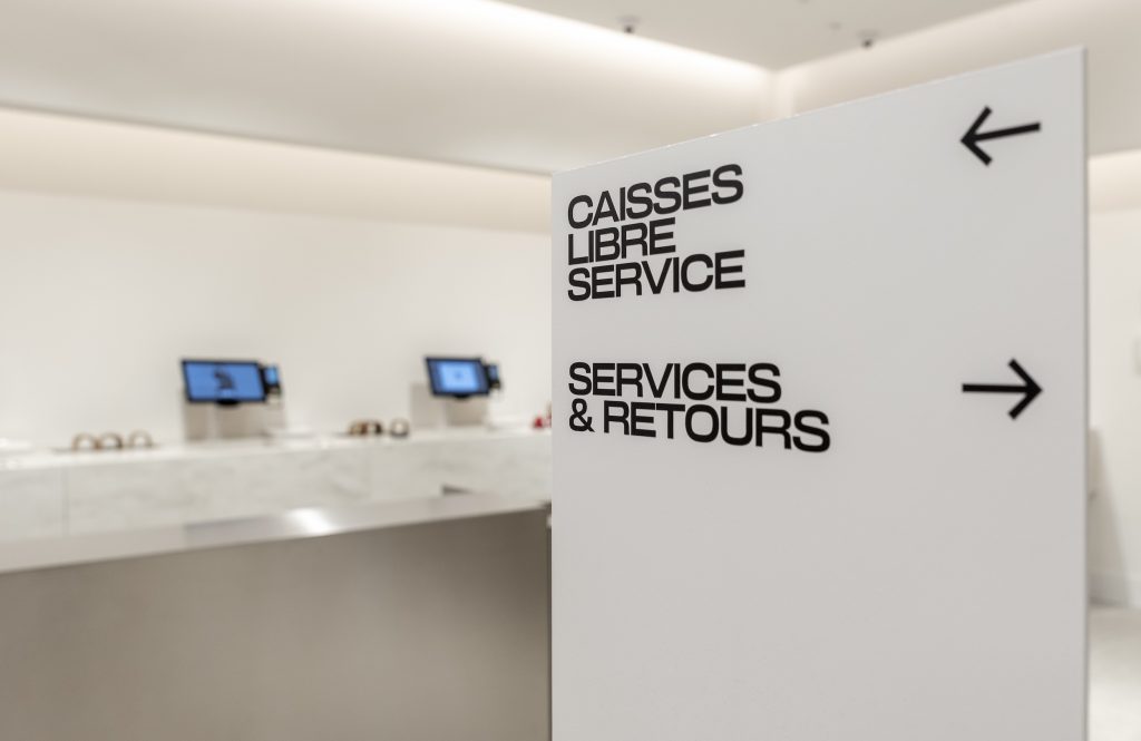 Espace caisses et services retours du magasin H&M Rosny avec comptoir minéral et finitions métalliques