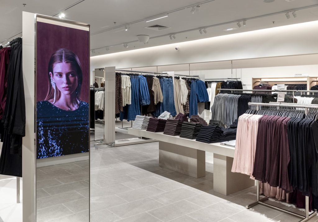 Intérieur du magasin H&M Rosny avec collections prêt-à-porter, mobilier retail et éclairage intégré