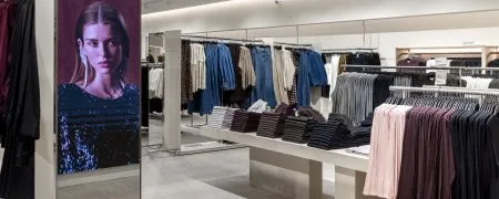 Intérieur du magasin H&M Rosny avec collections prêt-à-porter, mobilier retail et éclairage intégré
