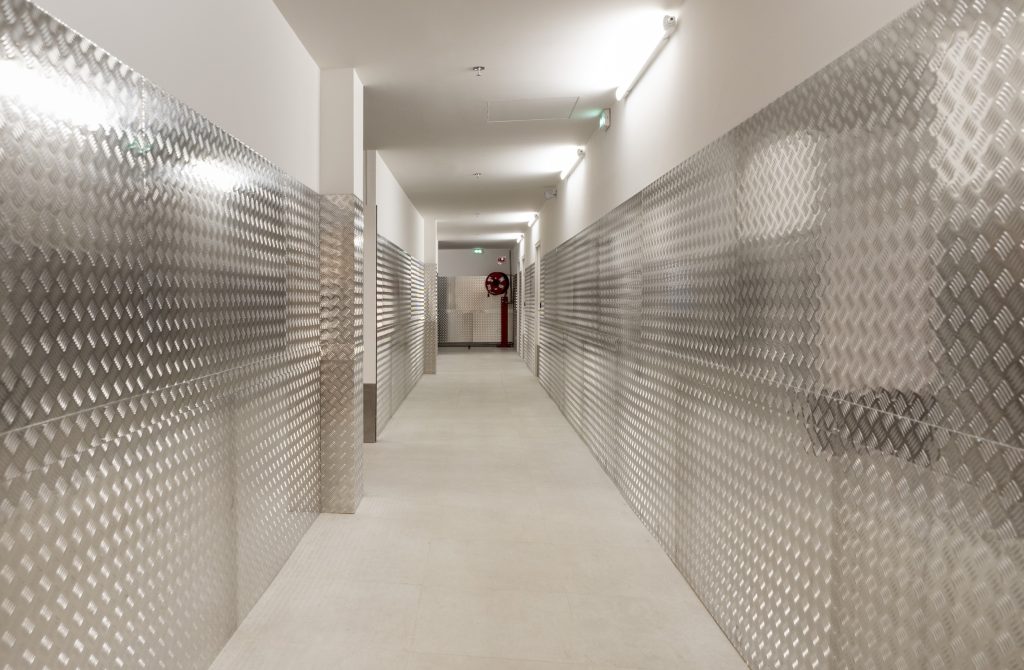 Couloir technique du magasin H&M Rosny avec habillage métallique et éclairage linéaire