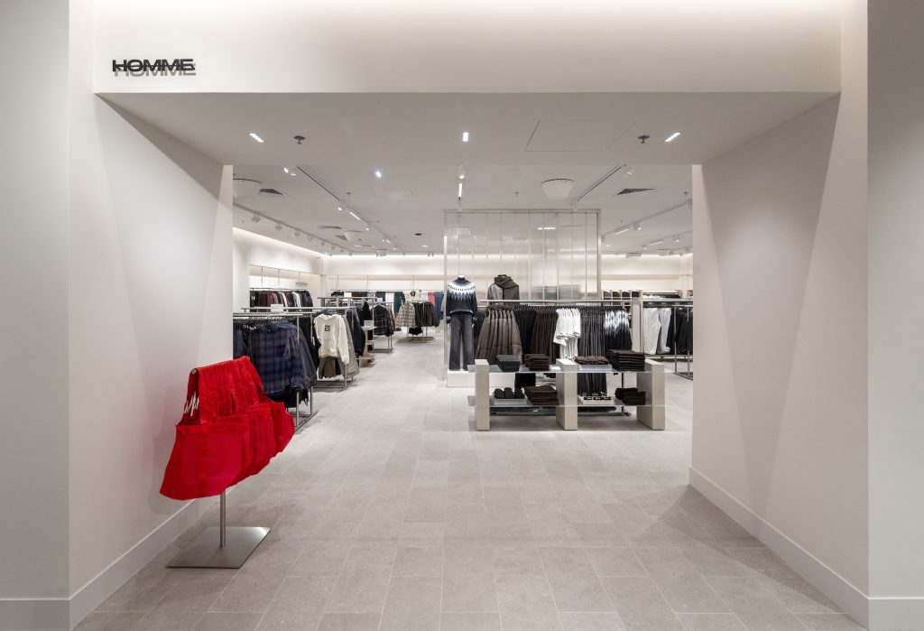 Entrée de l’espace Homme du magasin H&M Rosny avec allée centrale, mobilier retail et collections mode