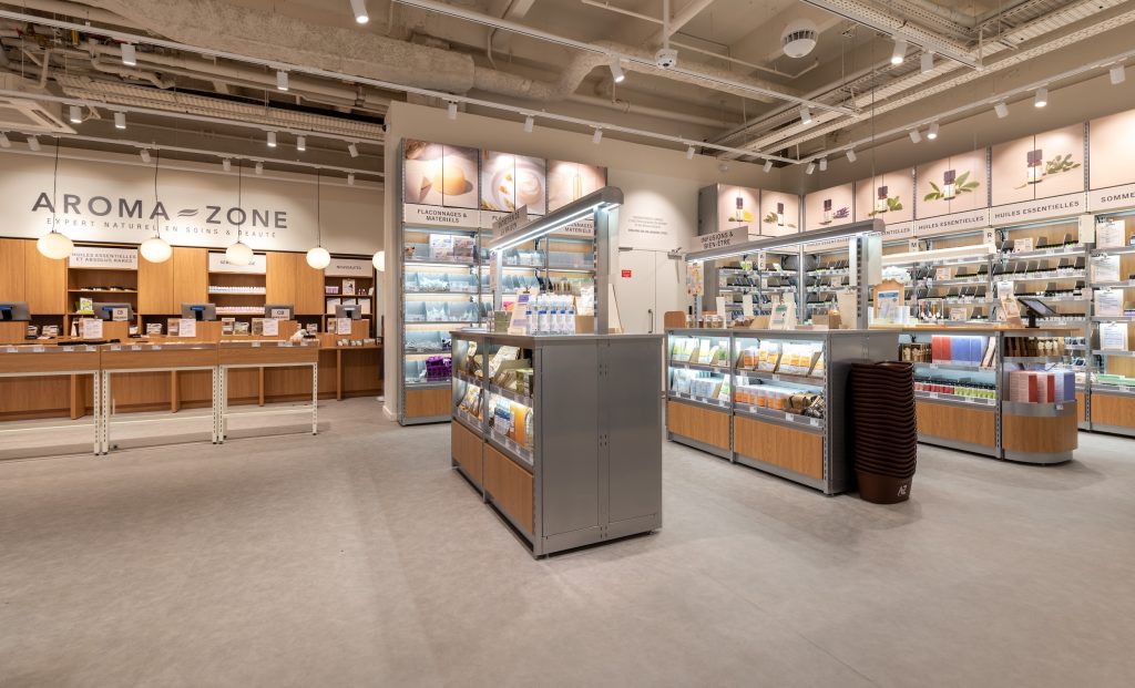 Vue globale de la boutique Aroma-Zone Vélizy avec caisses, linéaires, îlots produits et éclairage retail