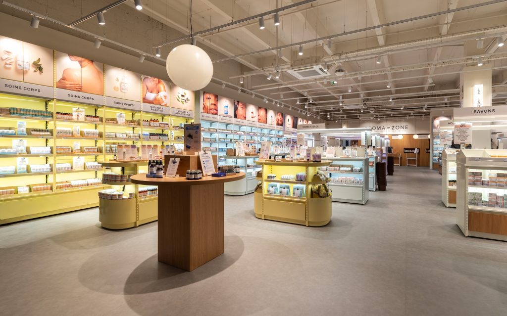 Intérieur de la boutique Aroma-Zone Vélizy avec rayons soins, mobilier bois et espace de vente lumineux