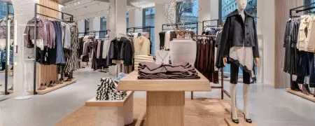 Intérieur de la boutique MANGO Lyon République avec mobilier bois, collections prêt-à-porter et concept New Med