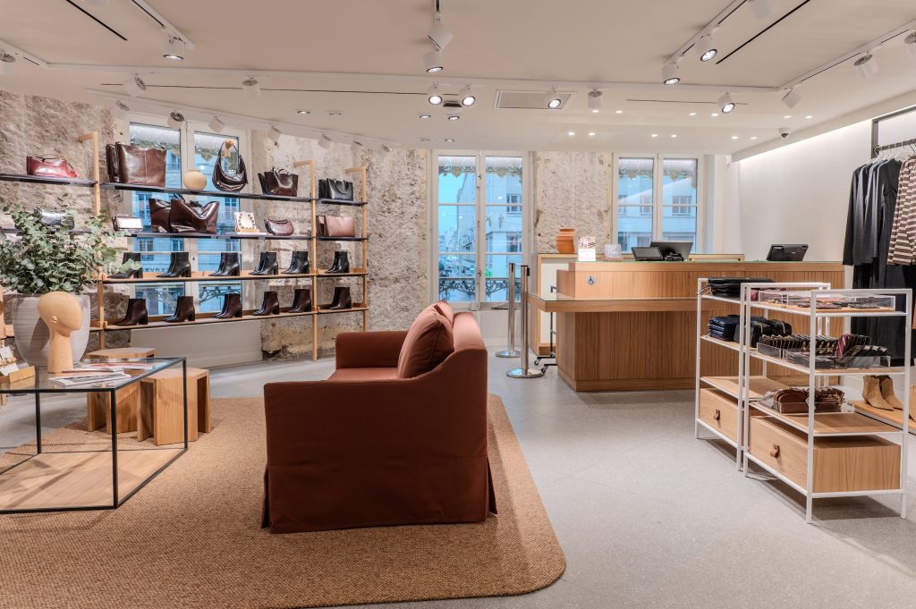 Espace accessoires de la boutique MANGO Lyon avec sacs, chaussures, canapé et mobilier de présentation