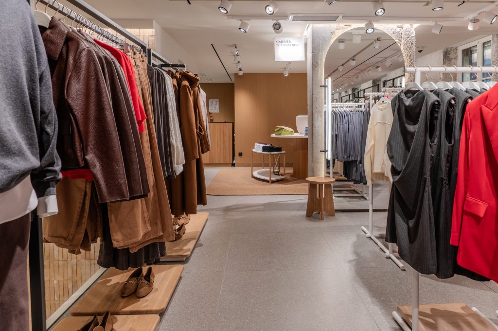 Rayons prêt-à-porter de la boutique MANGO Lyon avec portants, vêtements, signalétique cabines et éclairage retail
