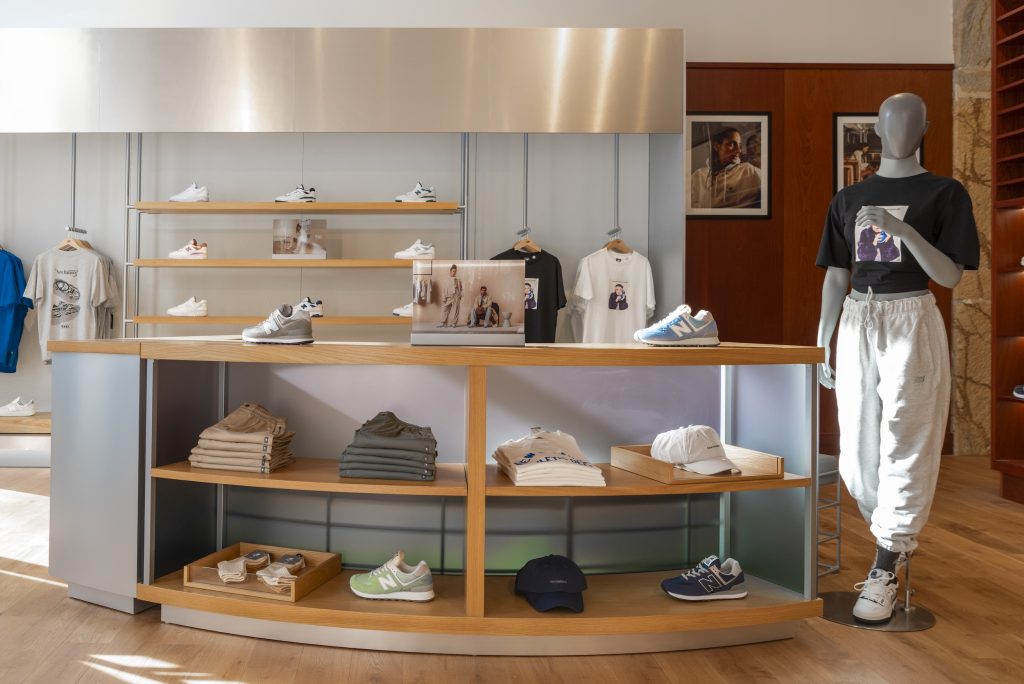 Étagères bois rétroéclairées dans la boutique New Balance Lyon avec sneakers exposées