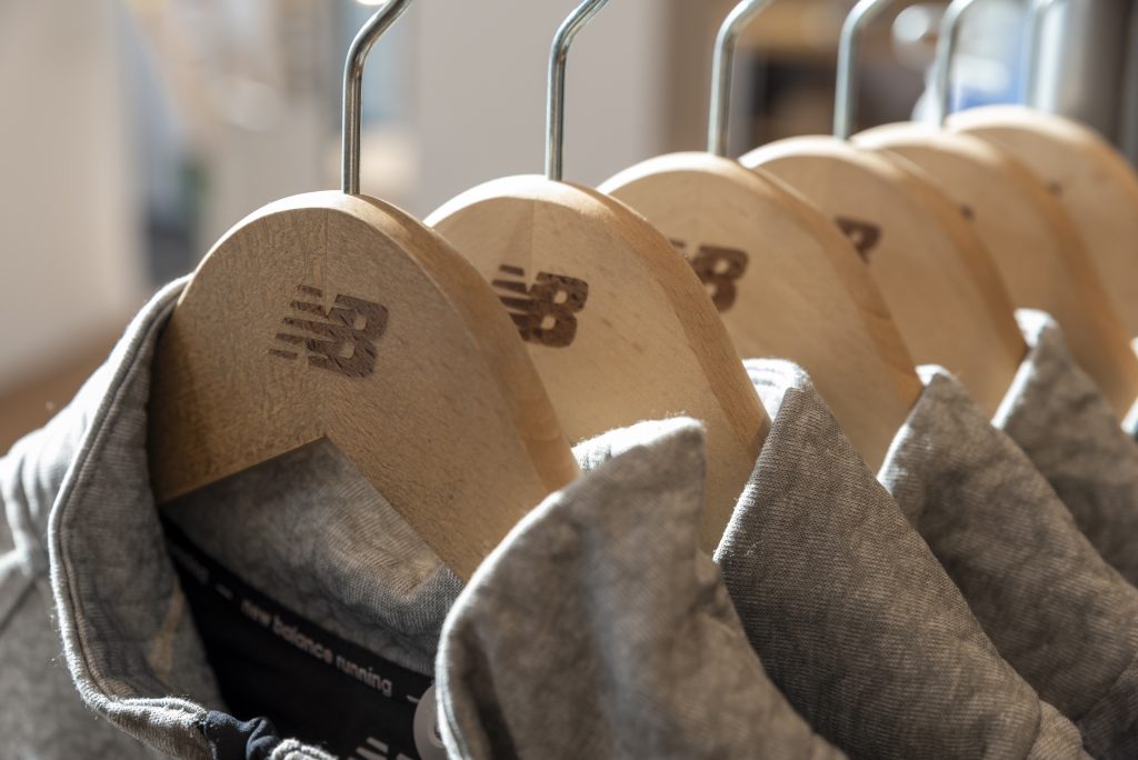 Cintres personnalisés New Balance dans la boutique Lyon avec vêtements sportwear