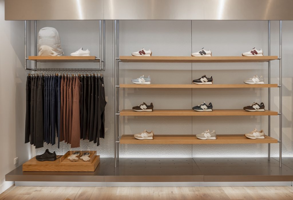 Espace essayage dans la boutique New Balance Lyon avec assises, comptoir caisse et linéaires chaussures