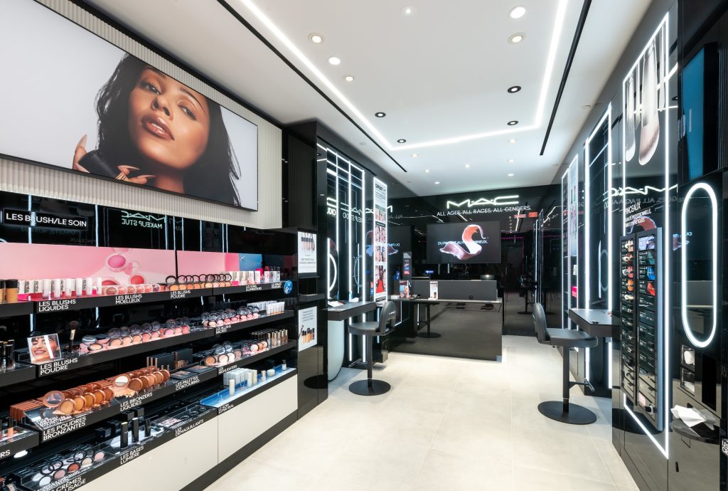 Vue intérieure de la boutique MAC Lyon Part-Dieu avec rayons maquillage, postes beauté et écran digital