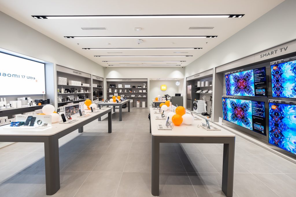Espace retail Xiaomi Qwartz avec mobilier blanc, produits high-tech et éclairage intégré