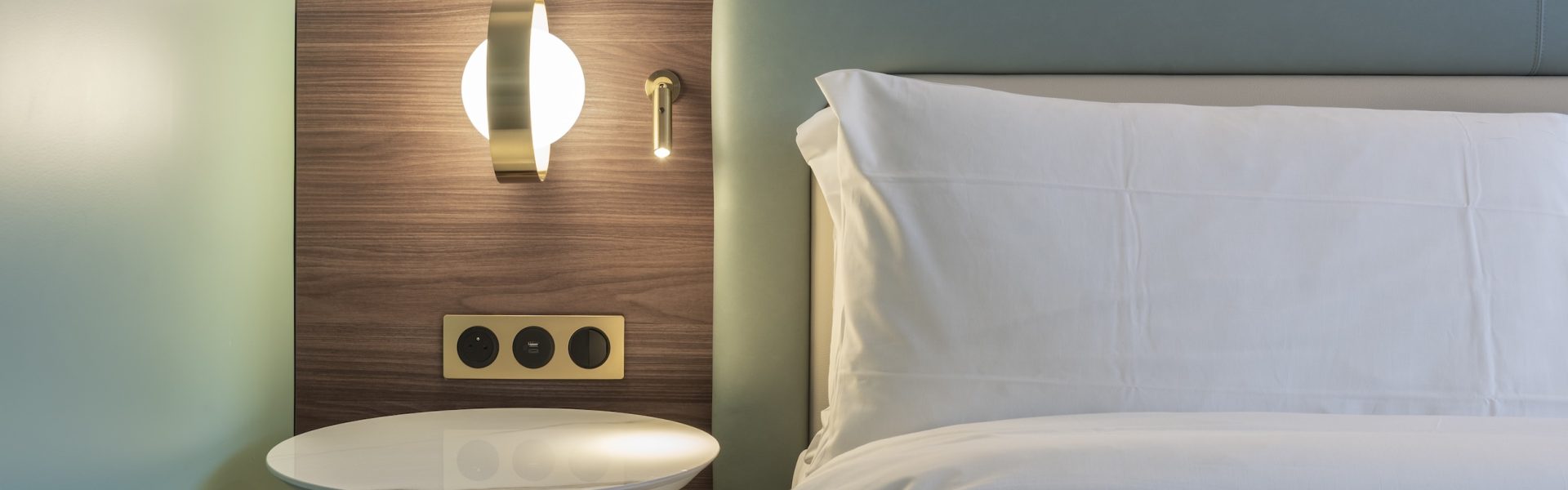 Tête de lit et mobilier bois dans une chambre d’hôtel